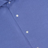 Close-up of the Excursionist Flex Print Sport Shirt in blue, crafted from cotton-stretch fabric and featuring white buttons. The shirt’s label at the collar displays the PETER MILLAR brand. The wrinkle-resistant material appears smooth and neatly pressed.