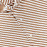A close-up of the PETER MILLAR Excursionist Flex Stripe Sport Shirt showcases its brown fabric with white vertical stripes, white buttons, and a blue label inside the collar. Crafted from wrinkle-resistant, cotton-stretch material, this shirt provides both comfort and easy care.