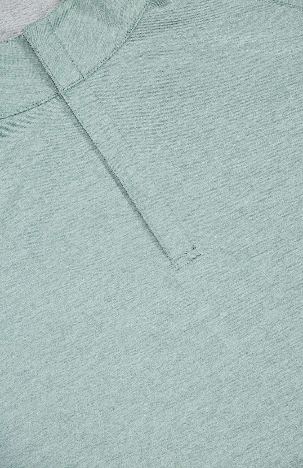 Close-up of the PETER MILLAR Stealth Performance Quarter-Zip Pullover in light green, featuring neat stitching, UPF 50+ sun protection fabric, and premium textured details.