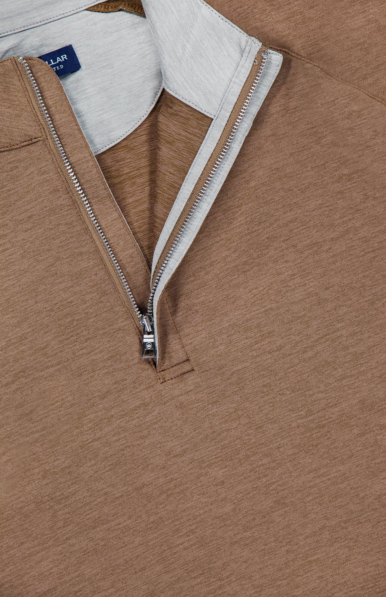 Close-up of the Stealth Performance Quarter-Zip Sweater by PETER MILLAR, showcasing its brown lightweight fabric, quarter-zip neckline with a partially unzipped silver zipper, light gray inner lining, and a navy collar tag.