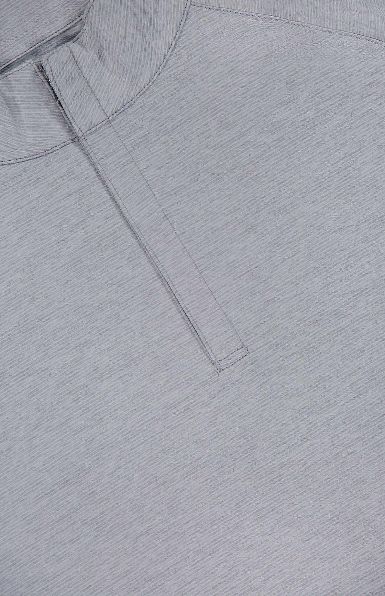 Close-up of the PETER MILLAR Stealth Stripe Performance Quarter-Zip Sweater in light gray, showcasing its lightweight design with a subtle pinstripe texture. Features include a partially visible collar and a vertical quarter-zip near the neckline, crafted with four-way stretch fabric for comfort and mobility.
