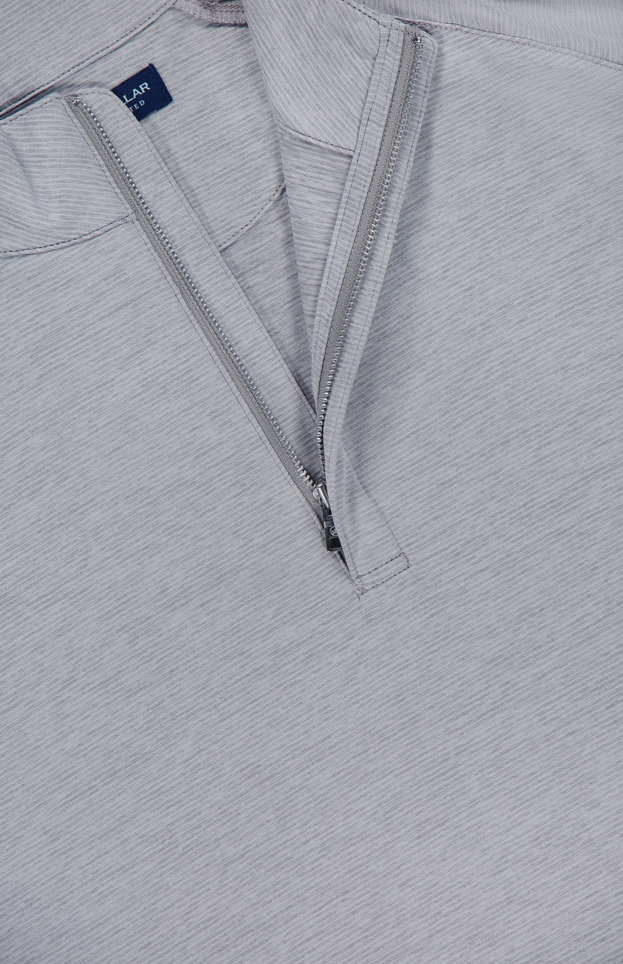 Close-up of the PETER MILLAR Stealth Stripe Performance Quarter-Zip Sweater in light gray, featuring a partially open zipper that reveals a blue tag inside the collar. The fabric showcases a subtle striped texture and offers four-way stretch for enhanced comfort and mobility.