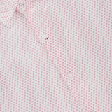 Close-up of the Tamarama Cotton Lyocell Sport Shirt by PETER MILLAR in light pink, showcasing a small red dot and circle graphic print. The stretch performance shirt’s label appears at the collar.