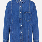 The 3.1 PHILLIP LIM Oversized Denim Shirt Jacket features long sleeves, white buttons, a left chest pocket, and seam detailing, shown against a plain light background.