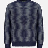 The PIACENZA Combed Pixel Stripe Crewneck Sweater is a fuzzy, long-sleeved navy sweater in virgin wool with a gray pixelated pattern, crew neckline, and ribbed cuffs and hem.
