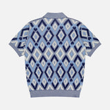 The PIACENZA Diamond Shaped Print Knit Polo Shirt features a blue, white, and light purple argyle pattern with ribbed collar, cuffs, and hem. Short sleeves; shown flat on a white background.