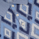 Close-up of the PIACENZA Diamond Shaped Print Knit Polo Shirt in navy, made in Italy, with blue and white geometric diamonds, striped collar, three buttons, and a visible Piacenza 1733 label.