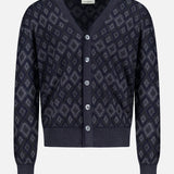 The Icon Argyle Stitch Cardigan by PIACENZA is a navy Italian wool V-neck with long sleeves, geometric diamond pattern, ribbed cuffs and hem, and five front buttons.