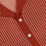 A close-up of the PIACENZA Striped Knit Short Sleeve Button Up Polo Shirt, featuring rust color, white vertical pinstripes, and white buttons, showcases Italian craftsmanship and the signature PIACENZA tag.