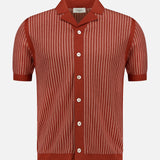 The PIACENZA Striped Knit Short Sleeve Button Up Polo Shirt in rust red features thin vertical white stripes, a collar, and white buttons, shown against a plain white background.