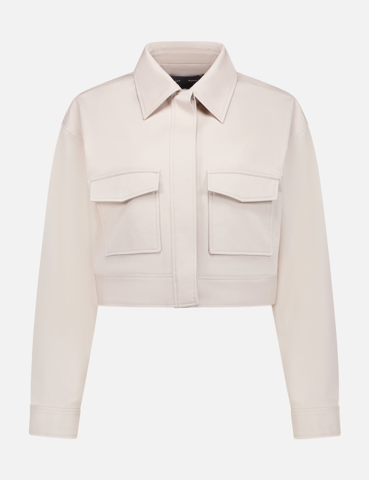 The PROENZA SCHOULER Dylan Jacket is a cropped, long-sleeve, light beige cotton-twill shirt jacket with a collar, front flap pockets, buttoned cuffs, and a hidden front closure, shown on a white background.