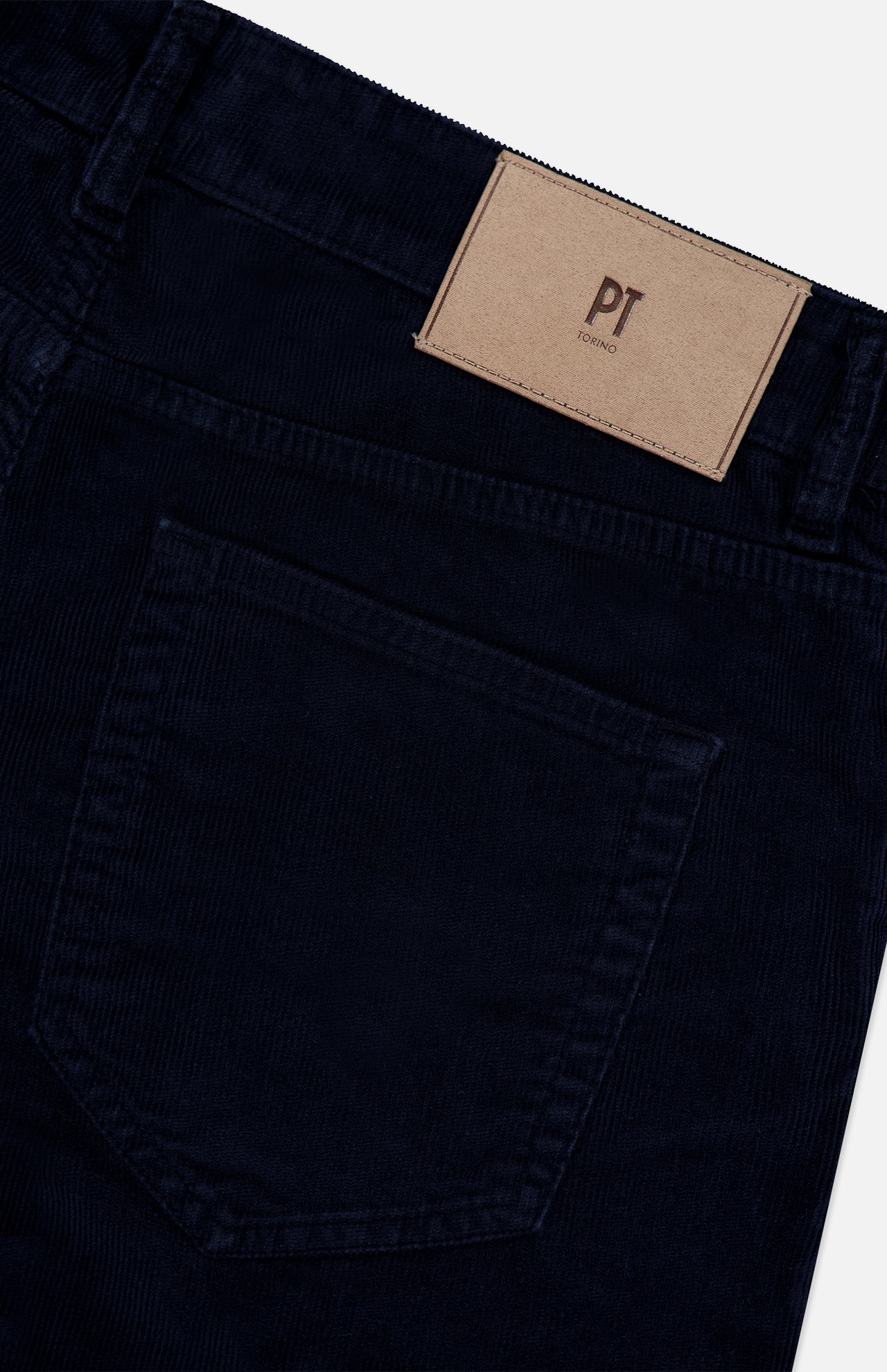 Close-up of the back pocket and waistband of the 1000 Wales Stretch Denim Jeans in dark blue, crafted from stretch-cotton denim and made in Italy, featuring a tan patch label with PT TORINO above the pocket.