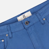 Close-up of the PT TORINO Cotton-Cashmere Stretch Tricotine Jeans in Azzurro, showcasing belt loops, a black button, and a visible white PT TORINO label near the waistband, all crafted in a classic 5-pocket design.