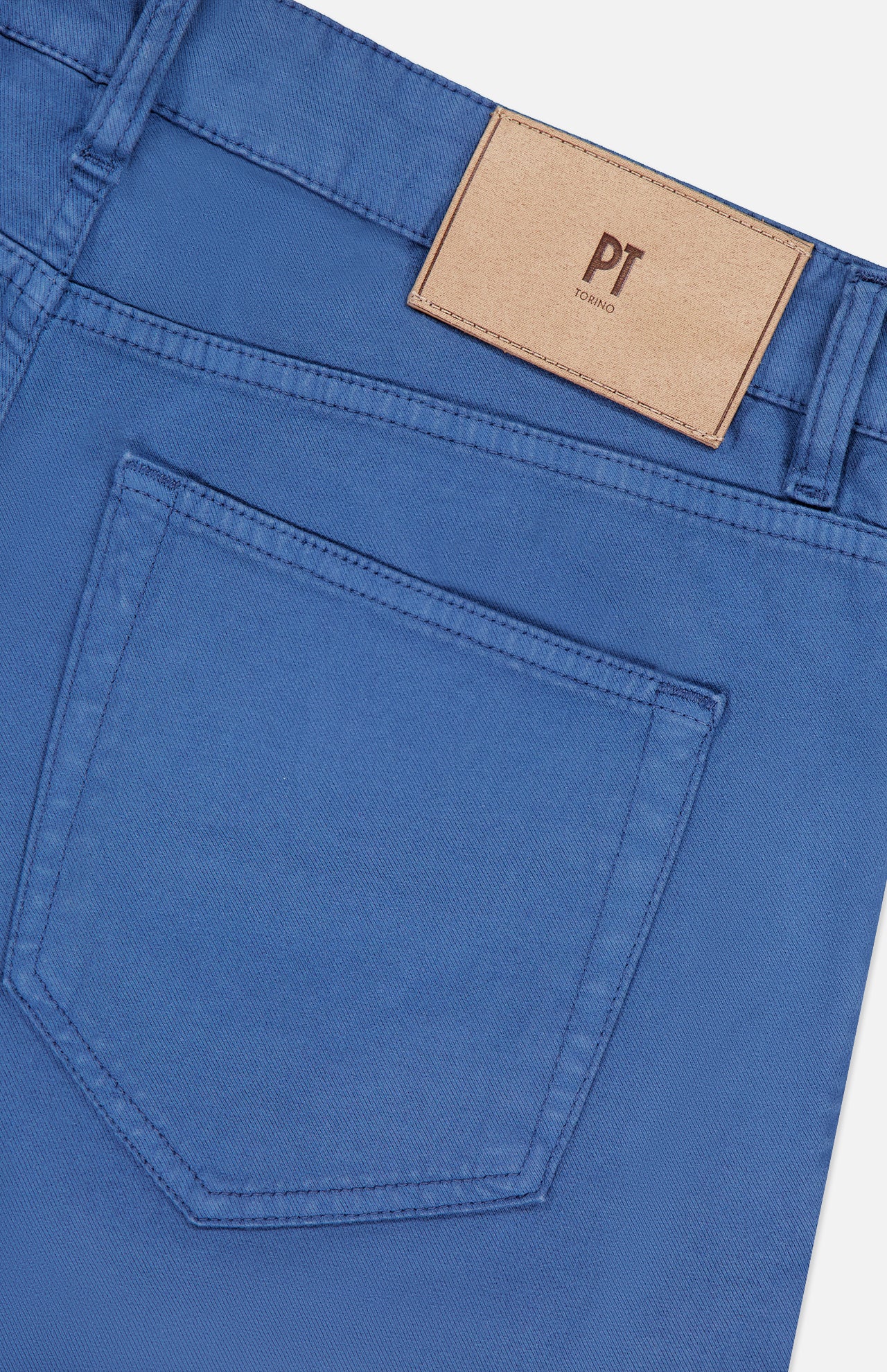 Close-up of the back pocket and waistband of the Cotton-Cashmere Stretch Tricotine Jeans in Azzurro by PT TORINO, showcasing a classic 5-pocket design with a beige leather PT TORINO patch above the pocket.