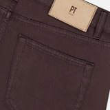 Close-up of the back pocket and waistband of PT TORINO Stretch Jeans in Testa Di Moro, featuring a beige label with the brand name above the pocket. The fabric, a cotton cashmere blend, gives these men's designer jeans a refined and soft texture.
