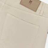 Close-up of the back pocket and waistband of the Cotton & Cashmere Stretch Tricotine Jeans in Stone by PT TORINO, featuring a brown rectangular leather patch with the brand’s logo above the pocket. Expertly crafted in Italy, these jeans combine cotton and cashmere for exceptional comfort and showcase a refined 5-pocket design that offers timeless style.