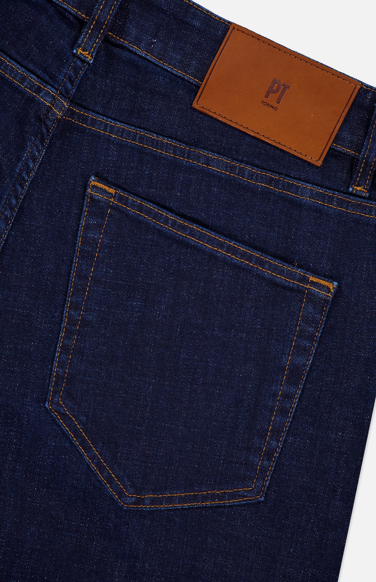 Close-up of the back pocket on PT TORINO Cotton Denim Stretch Jeans in dark blue, with a brown leather patch on the waistband, stitched details, and a subtle brand logo.