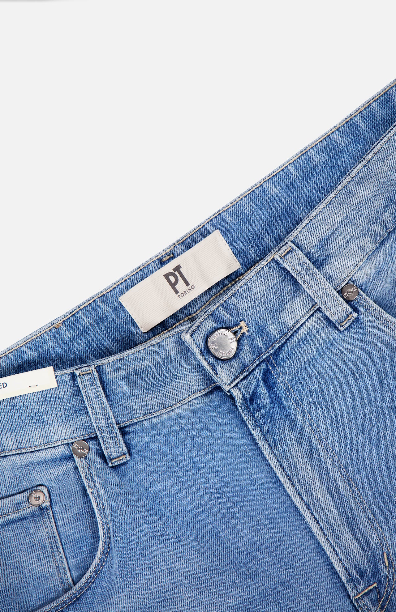 Close-up of PT TORINO Denim Stretch Jeans in light blue with a vintage wash, featuring waistband, belt loops, metal button, zipper, front pockets, and a fabric label with "PT" in black. Jeans are laid flat on a white background.