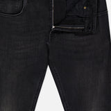 A pair of PT TORINO Jazz Denim Stretch Jeans in black, featuring a partially open zipper that reveals the waistband and front pockets, accented with gold-toned button and rivet details.
