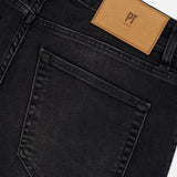 Close-up of the back of the Jazz Denim Stretch Jeans by PT TORINO in black, featuring a single rear pocket and a tan leather patch with “PT TORINO” embossed on the waistband.
