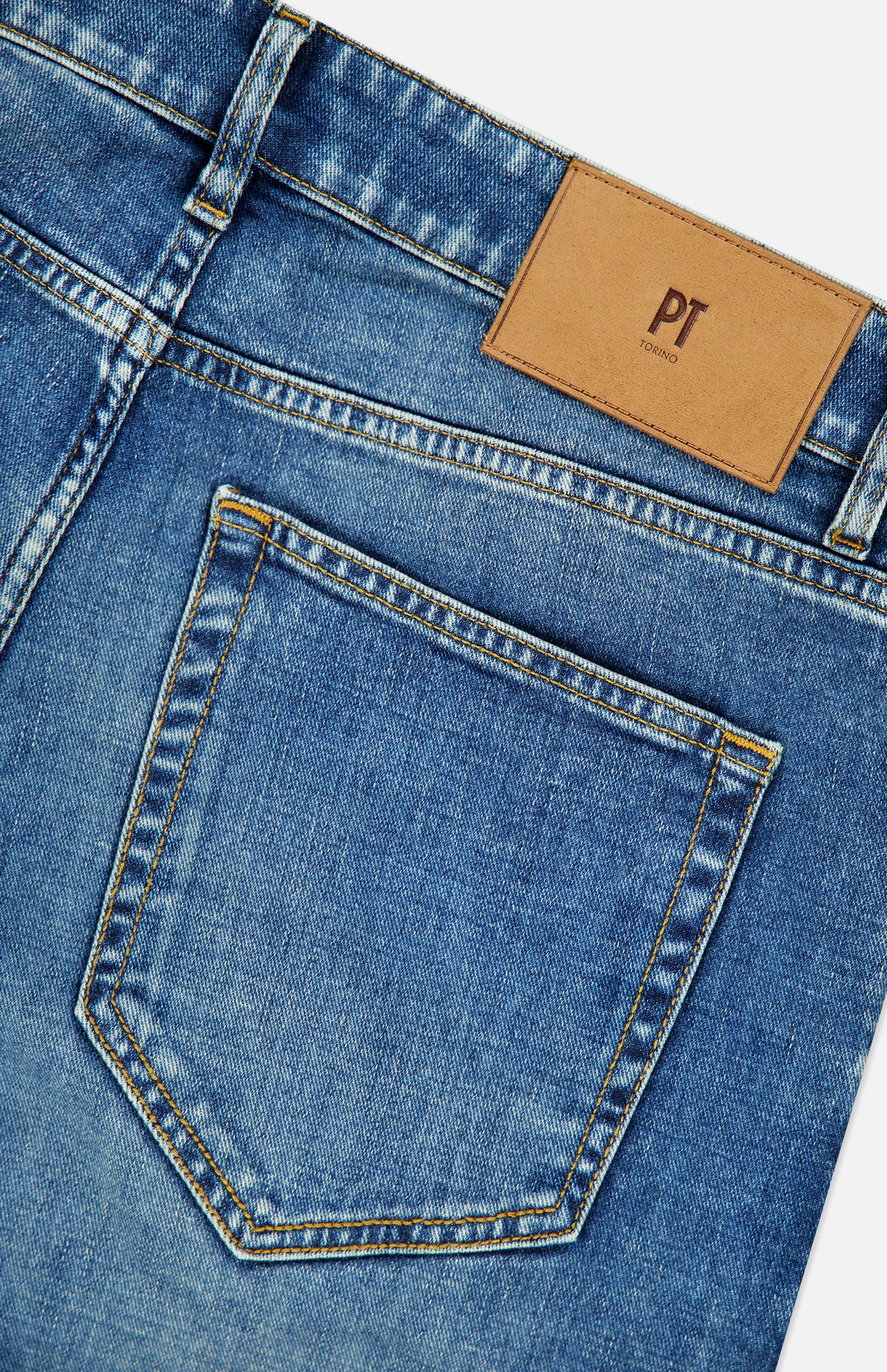 Close-up of the back pocket and waistband of the PT TORINO New Denim 5-Pocket Jeans in stretch blue denim, featuring a brown leather patch labeled PT TORINO above the pocket.