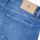 Close-up of the back of PT TORINO Soft Touch Light Stretch Jeans, showing a single back pocket and a tan leather patch with PT TORINO initials embossed near the waistband, made from comfortable stretch denim.