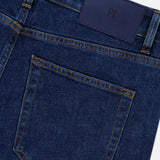 Close-up of the back of Stretch Japan Denim Jeans by PT TORINO in dark blue Japanese denim, featuring a single back pocket, belt loops, yellow stitching, and a dark blue leather patch on the waistband.