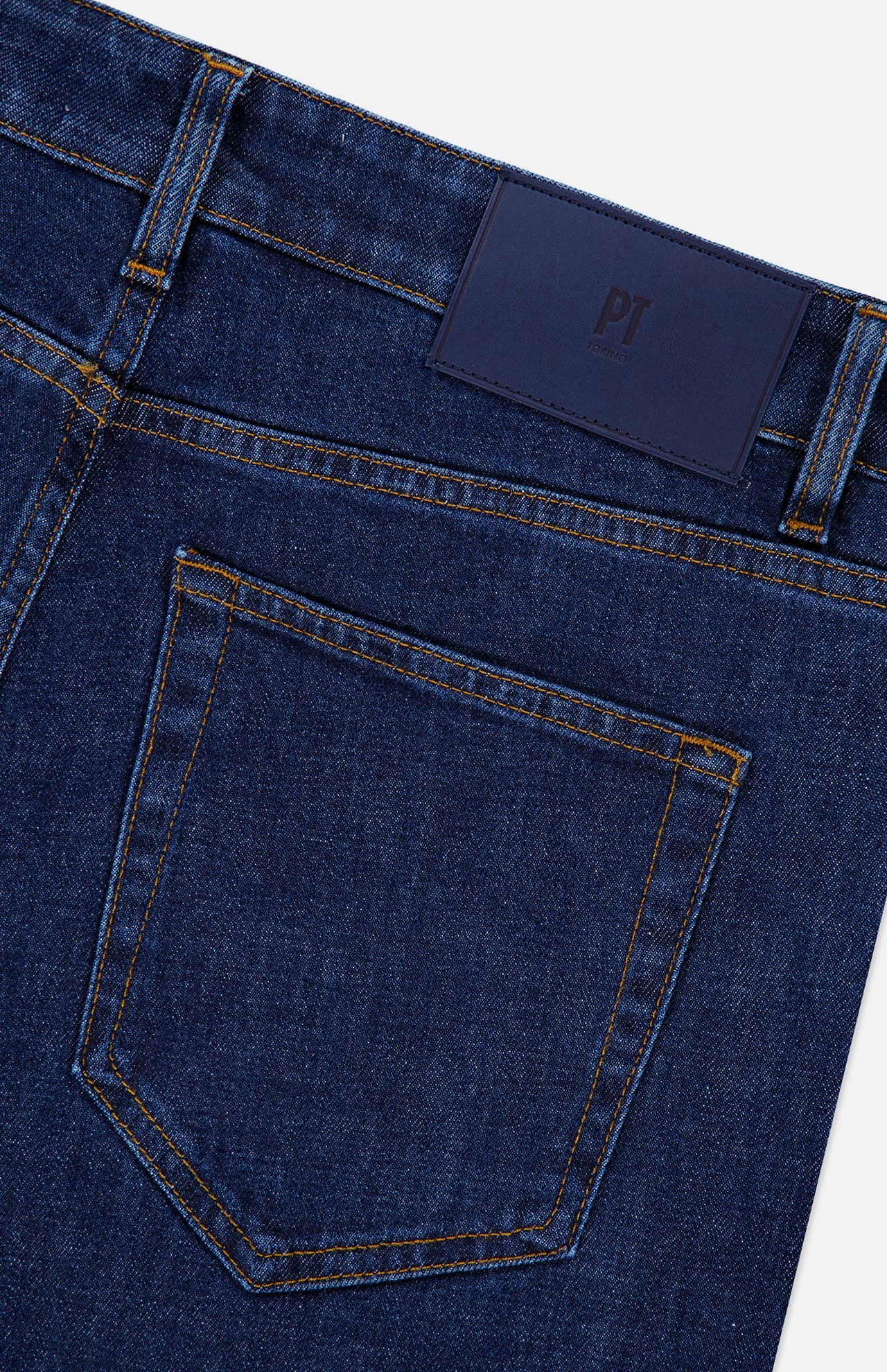 Close-up of the back of Stretch Japan Denim Jeans by PT TORINO in dark blue Japanese denim, featuring a single back pocket, belt loops, yellow stitching, and a dark blue leather patch on the waistband.