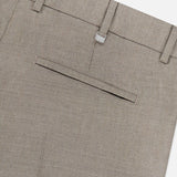 Close-up of the back of the Traveler Light Stretch Structure Trouser Pant by PT TORINO in beige, highlighting a single welt pocket, belt loops, and a small metallic PL tag near the waistband. Expertly tailored from stretch wool for comfort and versatility—ideal for travel and everyday wear.