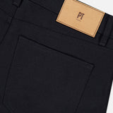 Close-up of the back of black Wool & Cashmere Flannel Pants showing a 5-pocket design with a pocket and a tan leather logo patch on the waistband.