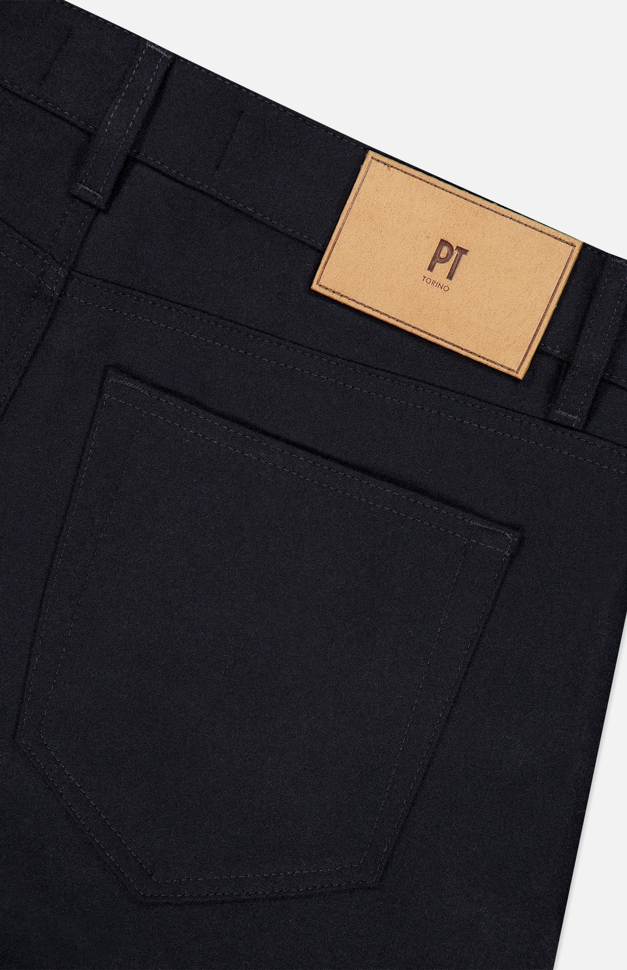 Close-up of the back of black Wool & Cashmere Flannel Pants showing a 5-pocket design with a pocket and a tan leather logo patch on the waistband.