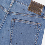 Close-up of the back pocket and waistband of RAG & BONE’s Harlow Ankle Straight Jean, featuring stud embellishments, orange stitching, a textured brown waistband patch, and a b logo on the pocket.
