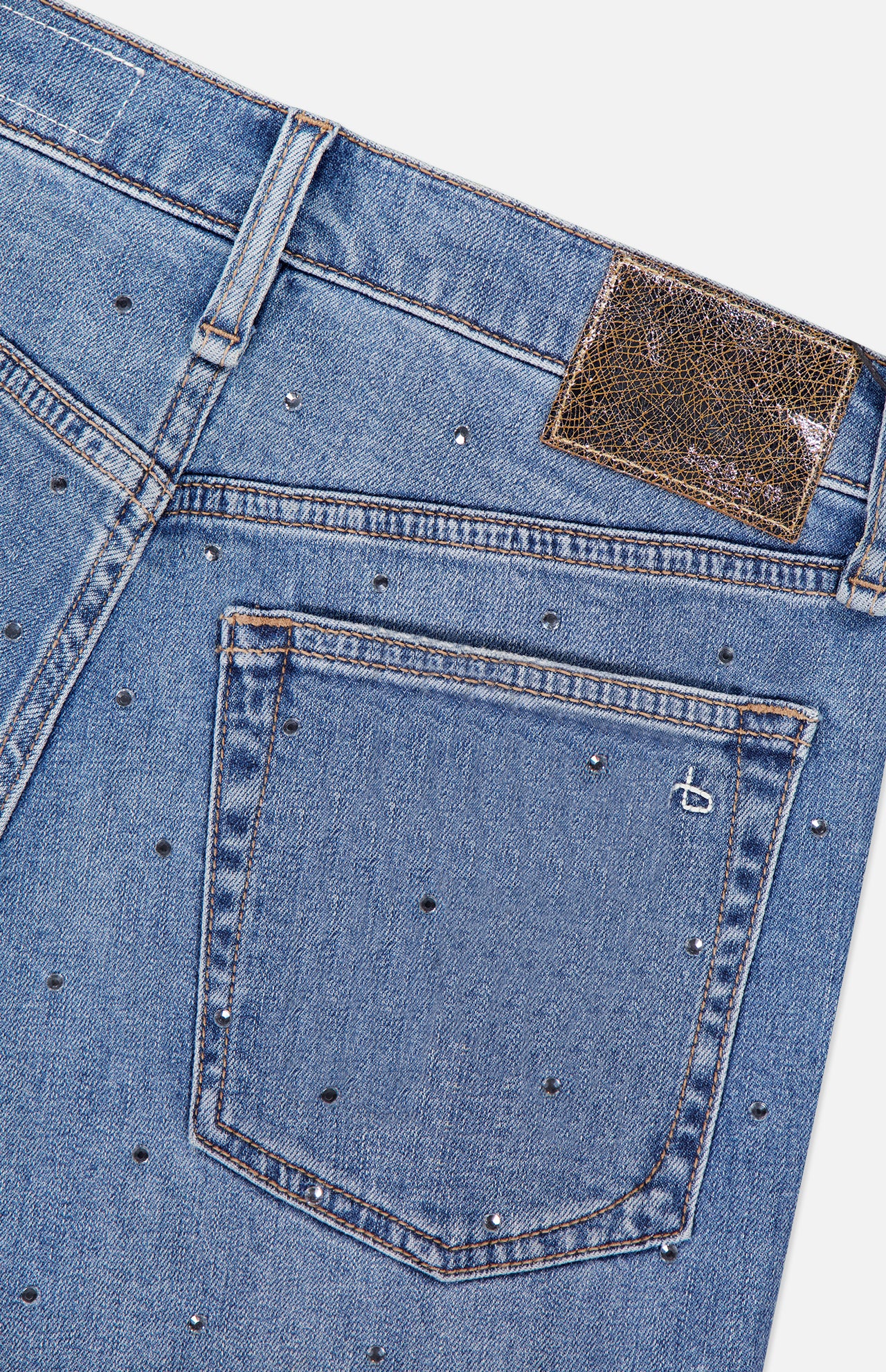 Close-up of the back pocket and waistband of RAG & BONE’s Harlow Ankle Straight Jean, featuring stud embellishments, orange stitching, a textured brown waistband patch, and a b logo on the pocket.