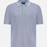 The RAG & BONE Harvey Tipped Polo Shirt features lightweight cotton in pale blue, a ribbed texture, white-trimmed collar, three-button placket, and subtle vertical stripes. Displayed on a plain white background.