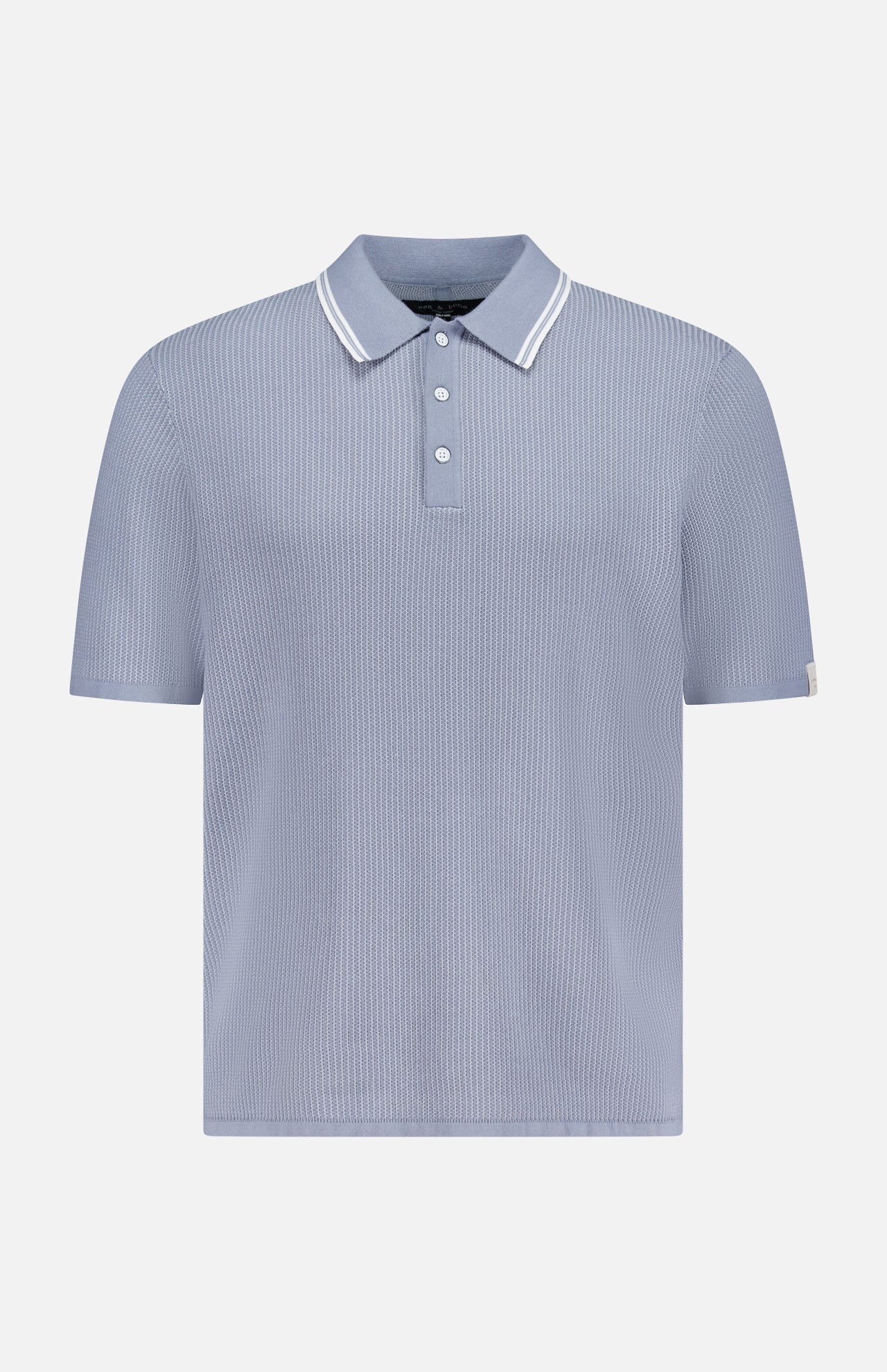 The RAG & BONE Harvey Tipped Polo Shirt features lightweight cotton in pale blue, a ribbed texture, white-trimmed collar, three-button placket, and subtle vertical stripes. Displayed on a plain white background.