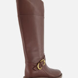 The Hayden Leather Riding Boot by RAG & BONE is a knee-high brown leather boot with a low heel and gold buckle detail near the ankle, shown against a white background.