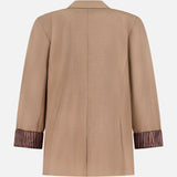 The Jennifer Combo Blazer by RAG & BONE is a tan wool-blend jacket with long sleeves, notched collar, and relaxed fit. Shown from the back, the rolled-up sleeves reveal a brown and white striped lining.