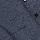 Close-up of the RAG & BONE Becker Knit Sportcoat in dark grey, featuring a herringbone pattern crafted from lightweight cotton-blend fabric, with details including a front pocket, sleeve buttons, and part of the lapel.