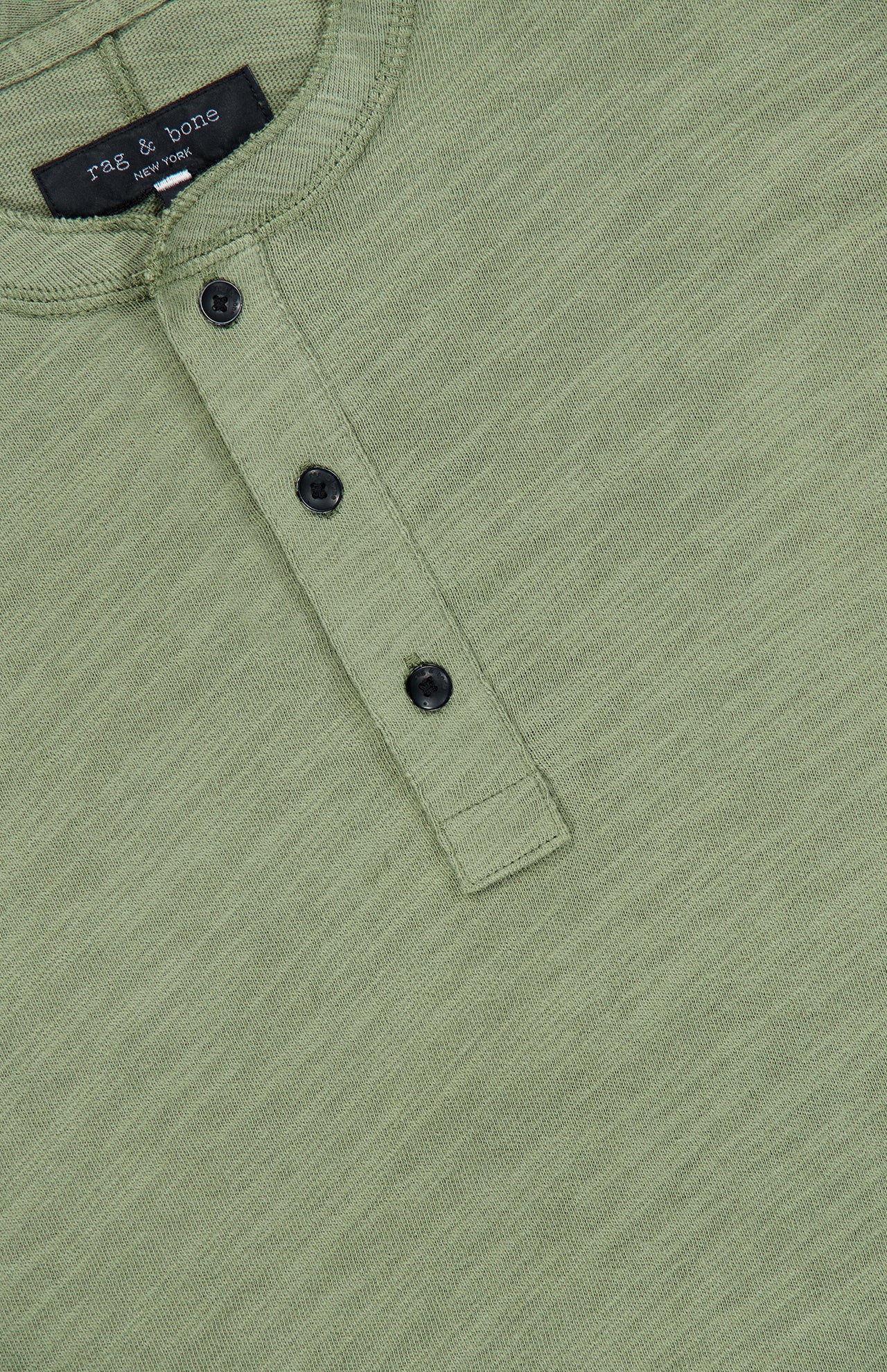 Light green, textured cotton Classic Flame Henley Shirt by RAG & BONE, featuring three black buttons and a visible brand label at the neck. The shirt is laid flat to showcase the button placket and part of the collar—making it a versatile casual wardrobe staple.