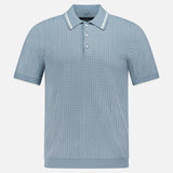 The Harvey Rib Polo Shirt by RAG & BONE features a light blue-grey hue, textured retro-inspired stitch, short sleeves, a three-button placket, and a collar with white stripe trim. Displayed on a plain white background.