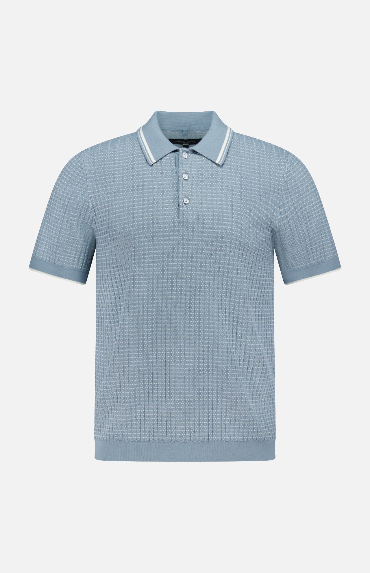 The Harvey Rib Polo Shirt by RAG & BONE features a light blue-grey hue, textured retro-inspired stitch, short sleeves, a three-button placket, and a collar with white stripe trim. Displayed on a plain white background.