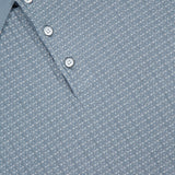 Close-up of the RAG & BONE Harvey Rib Polo Shirt, a blue-grey sweater with a vintage vibe, featuring a light blue pattern, white stripe on the collar, three white buttons, and a subtle geometric texture.