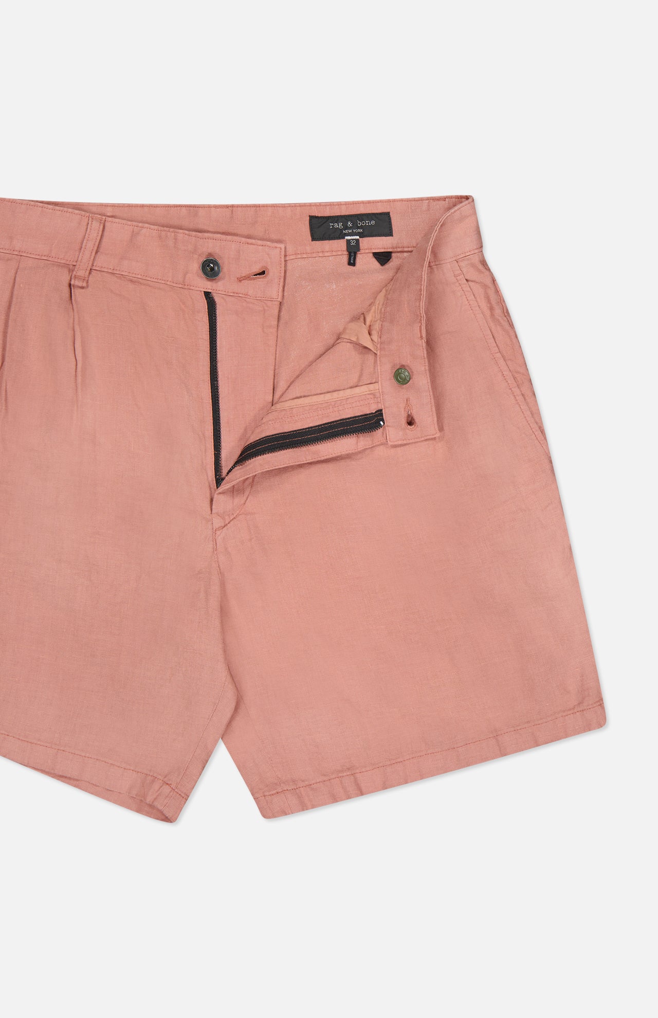 The Jackson Pleated Linen Short by RAG & BONE in pink features a classic fit, partially open zipper and button closure, visible waistband, and front pocket. The shorts are laid flat against a white background.