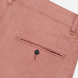 Close-up of the back of the RAG & BONE Jackson Pleated Linen Short, featuring a single welt pocket with a dark button and belt loops along the waistband. Shown in light brown or dusty rose classic fit linen.