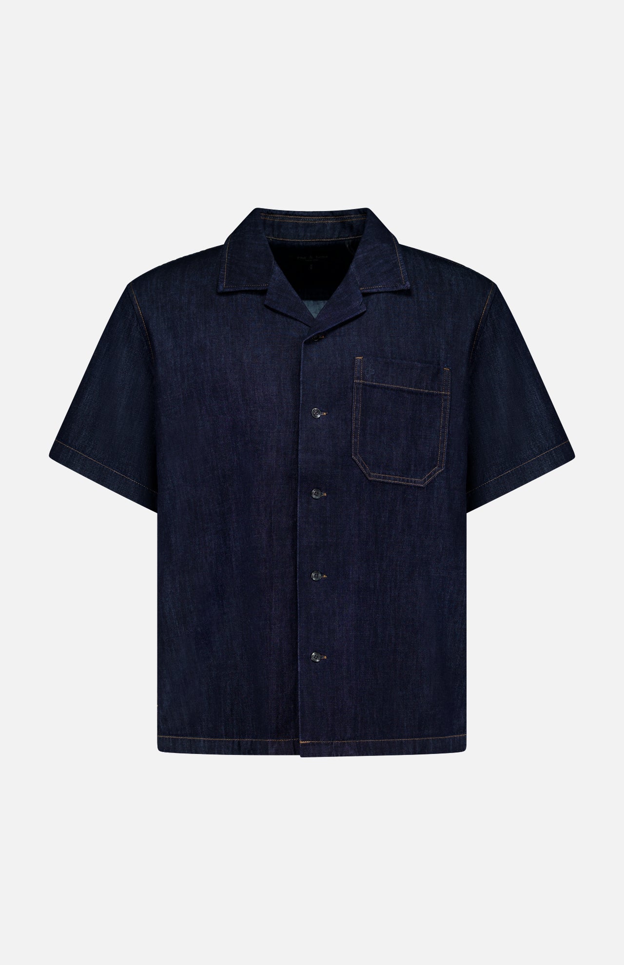 The RAG & BONE Resort Denim Shirt is a short-sleeved, dark blue featherweight denim camp shirt with a button-up front, notched collar, single chest pocket, and tan stitching, shown against a plain white background.
