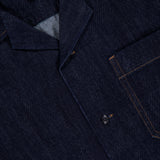 A close-up of the RAG & BONE Resort Denim Shirt features black buttons, orange stitching, a chest pocket, and a branded collar label—an effortless choice for resort style.