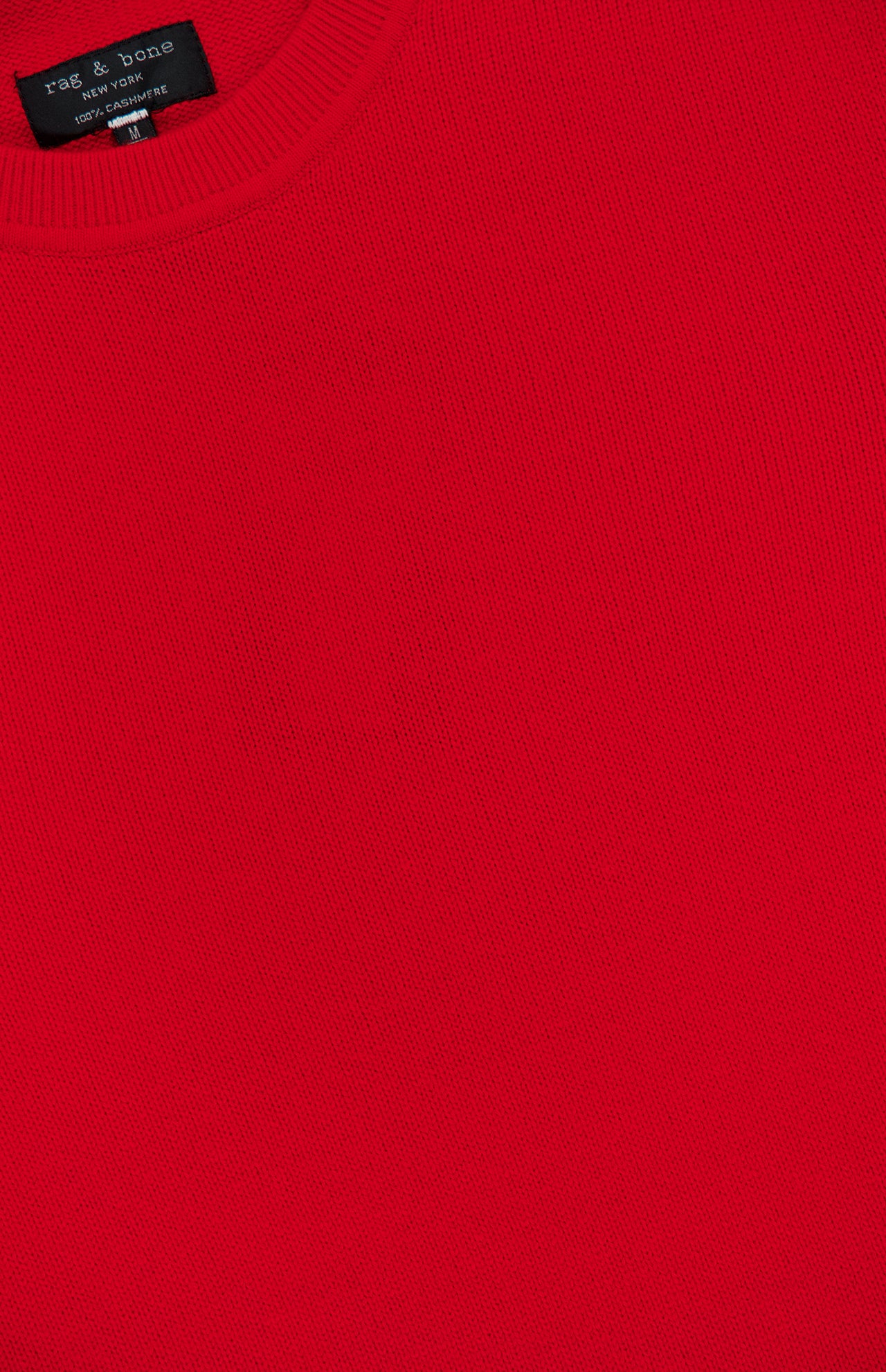 Close-up of a red Vernon Cashmere Crewneck Sweater by RAG & BONE, showing the crew neckline and part of a black brand tag.