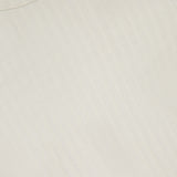 Close-up of the RAG & BONE Natalia Long Sleeve Ribbed Shirt in white, featuring a round neckline, vertical textured lines, and a visible black label—an excellent display of minimalist style.