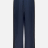 Back view of the RAG & BONE Olivia Contrast Stripe Pant in relaxed fit navy satin, featuring an elastic waistband and black side panels, shown on a plain white background.