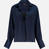 The RAG & BONE Venus Popover Removable Cami Blouse is a dark navy satin, long-sleeved, collared top with wide cuffs, a loose fit, and an open front that reveals a hint of black lace. Features a removable camisole for versatile styling.